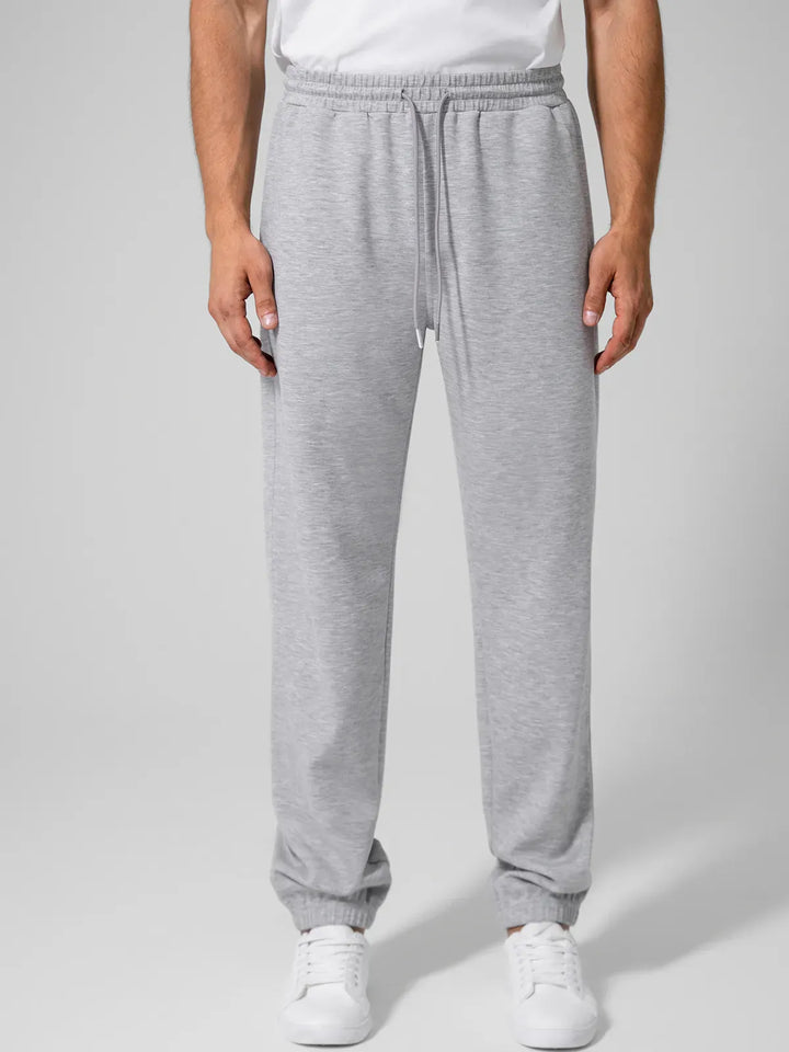 A model wearing a BRXL® Men's Four Pockets Drawstring Waist Activewear Sweatpants in Grey / XS