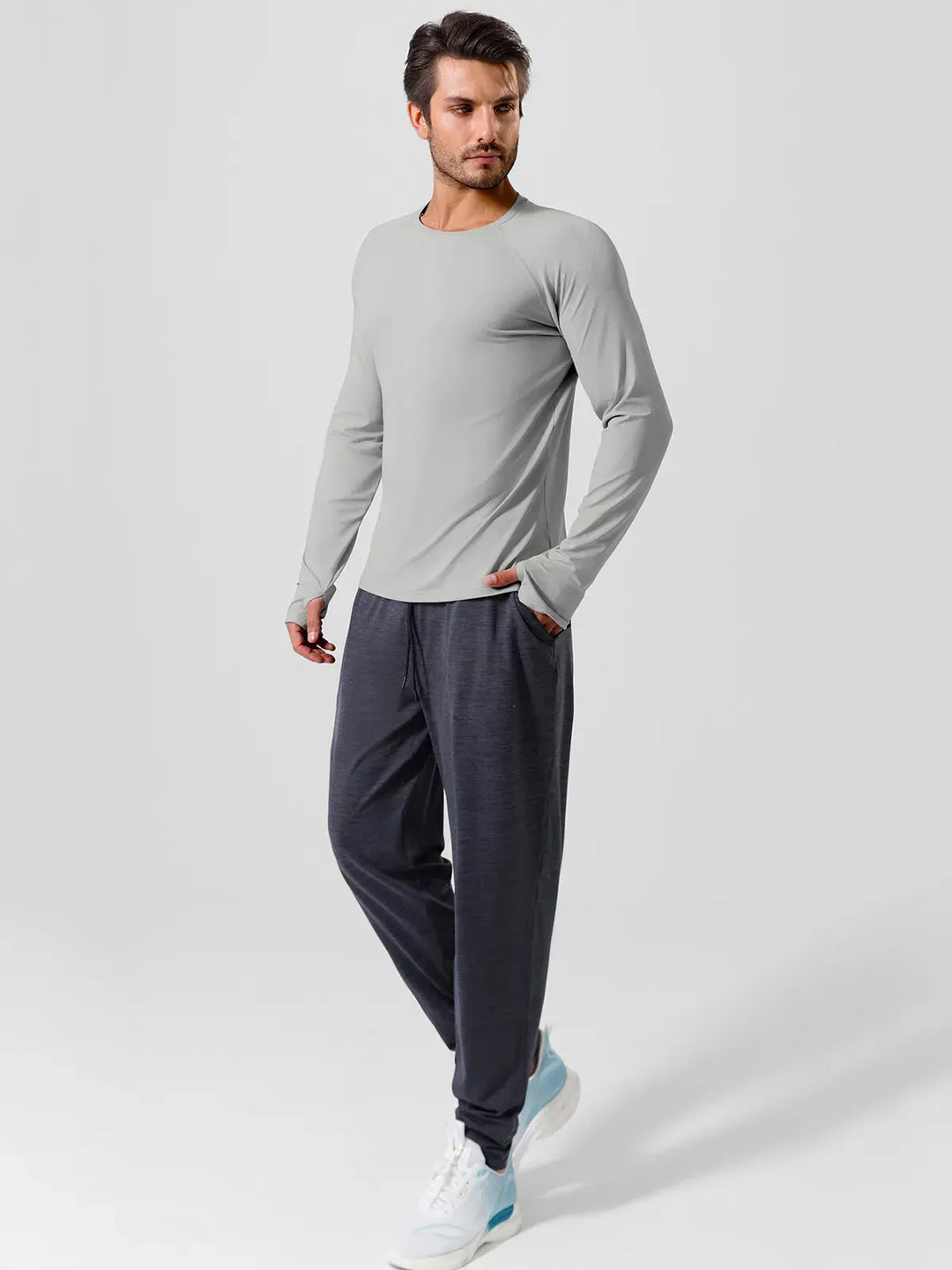 A model wearing a BRXL® Men’s Long Sleeve Thumbhole Activewear Shirt in