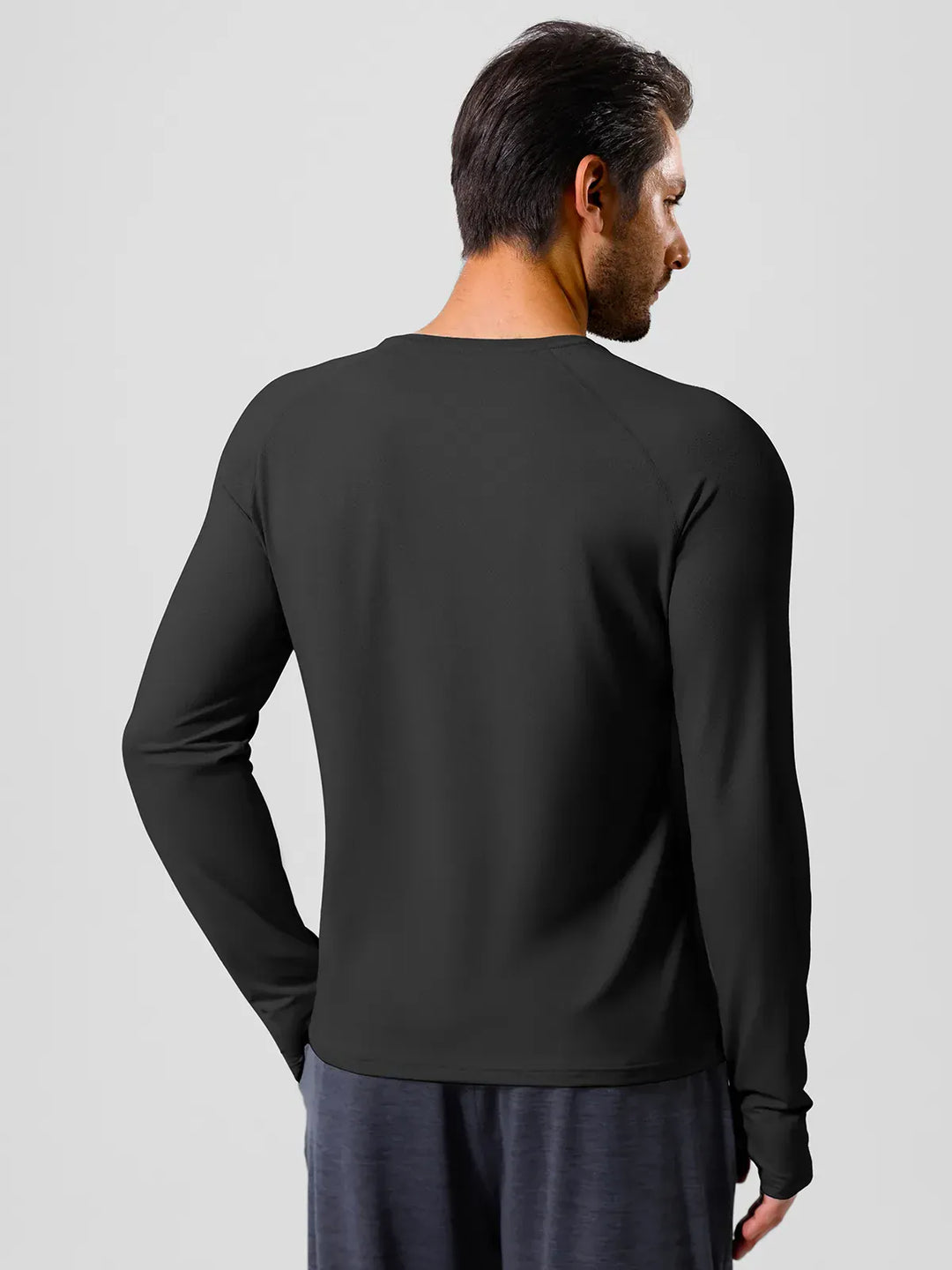 A model wearing a BRXL® Men’s Long Sleeve Thumbhole Activewear Shirt in