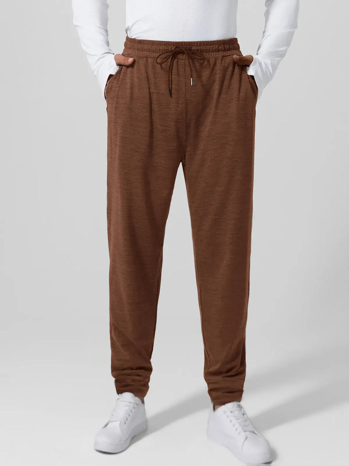 A model wearing a BRXL® Men’s Smooth Four Pockets Tapered Joggers in Brown / S