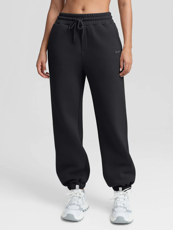 A model wearing a BRXL® Oversized Fleece Travel Jogger Sweatpants with Pockets Black / XS