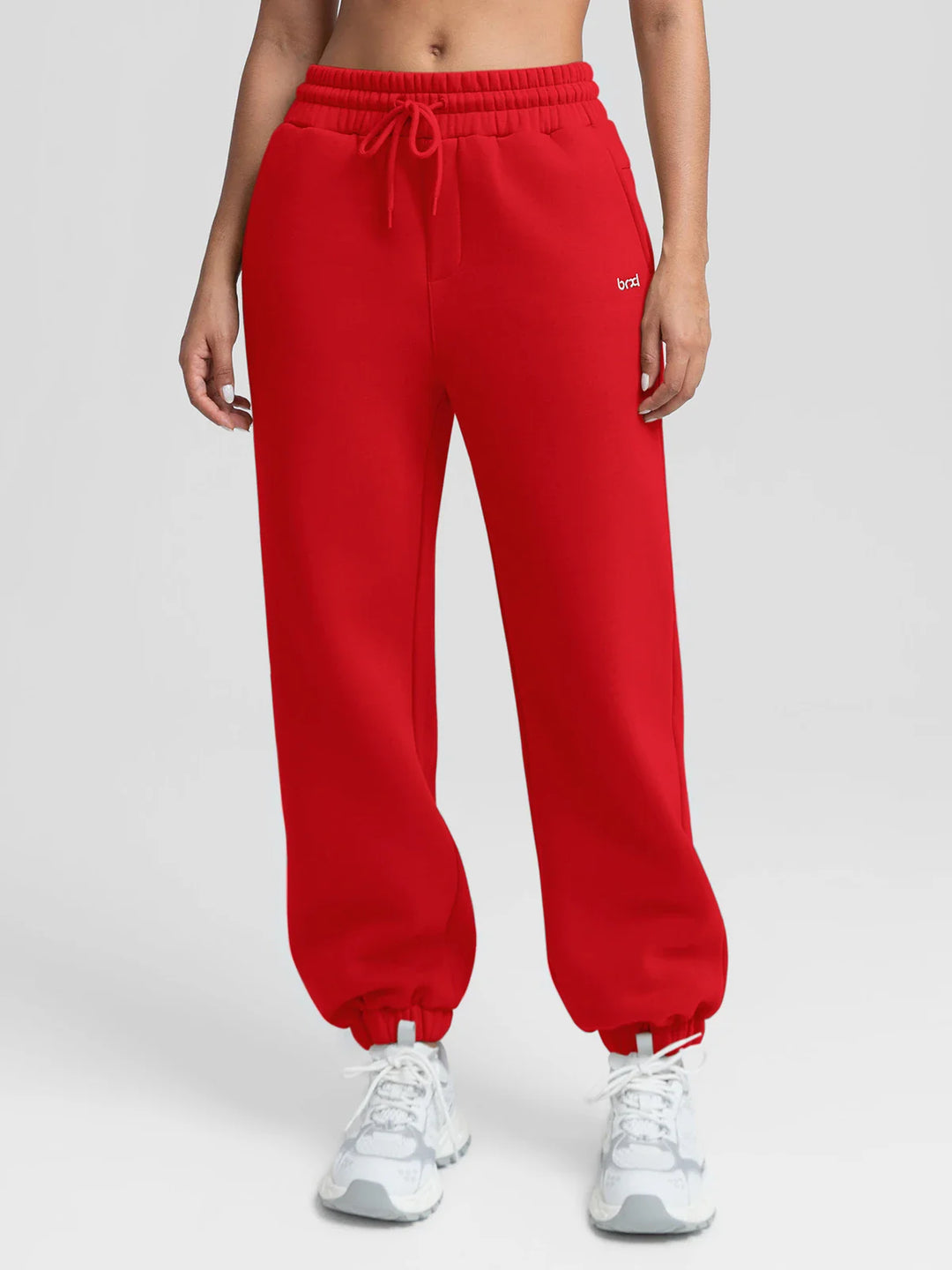 A model wearing a BRXL® Oversized Fleece Travel Jogger Sweatpants with Pockets Ruby Red / XS