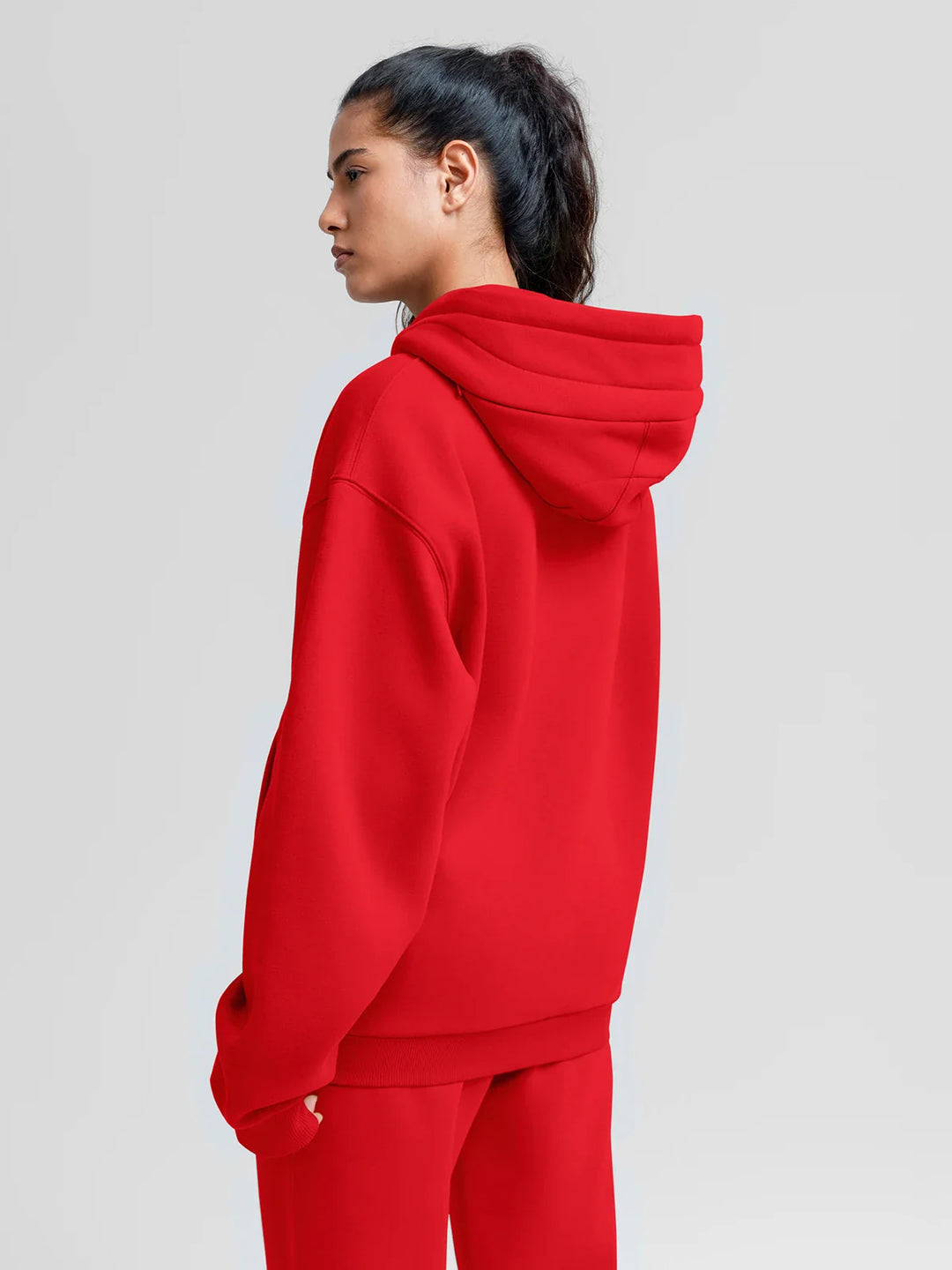 A model wearing a BRXL® Oversized Travel Pullover Hoodie with Headphone Slot