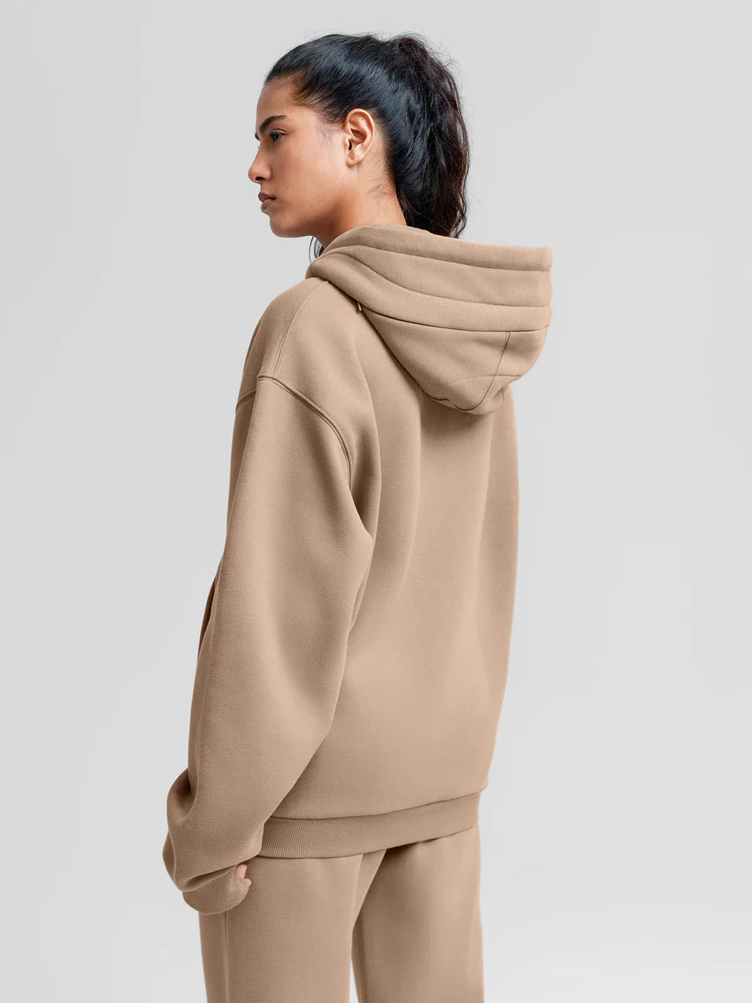 A model wearing a BRXL® Oversized Travel Pullover Hoodie with Headphone Slot
