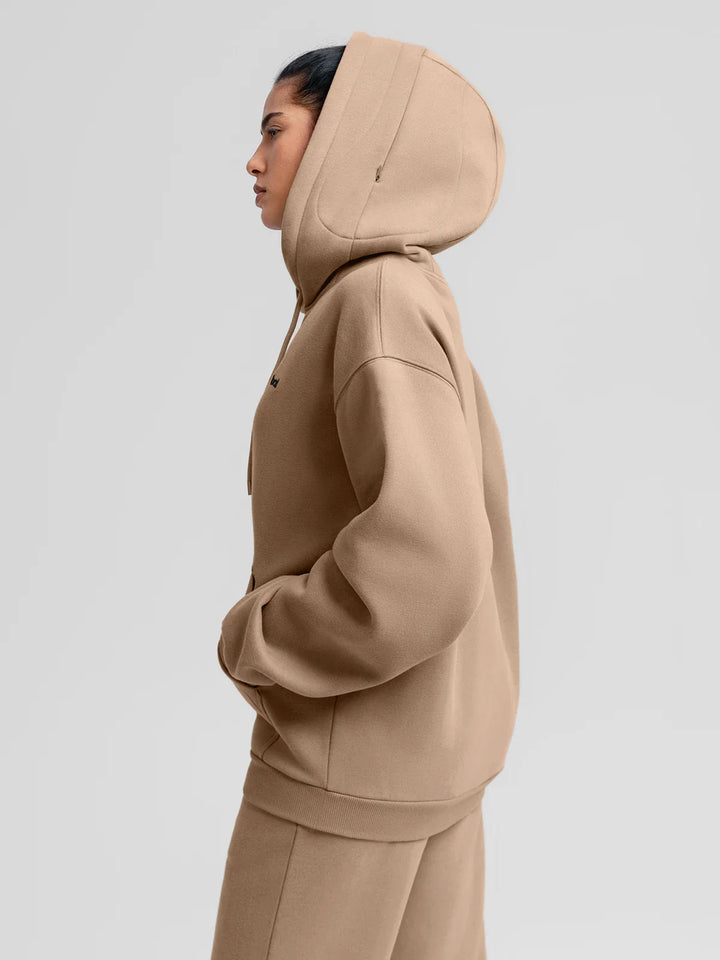A model wearing a BRXL® Oversized Travel Pullover Hoodie with Headphone Slot
