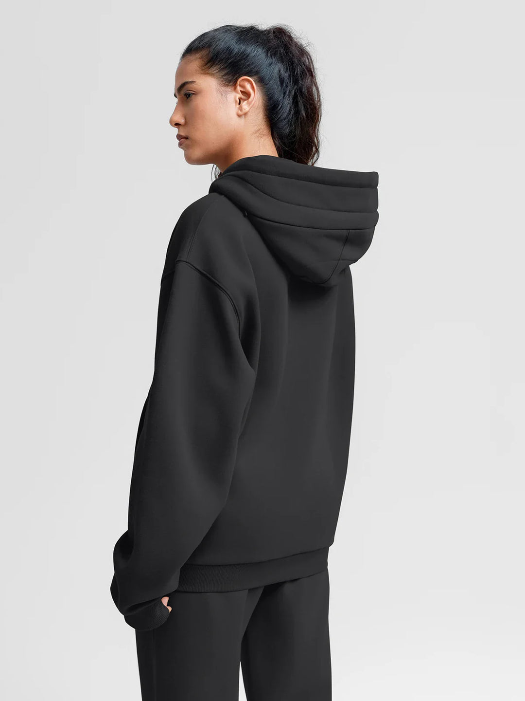 A model wearing a BRXL® Oversized Travel Pullover Hoodie with Headphone Slot