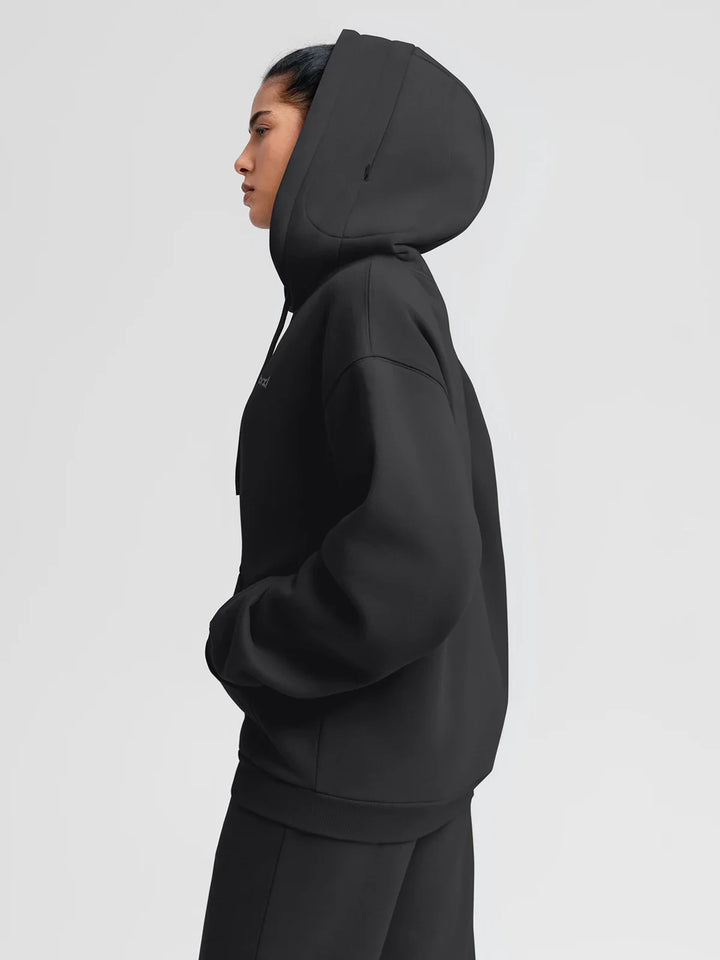 A model wearing a BRXL® Oversized Travel Pullover Hoodie with Headphone Slot