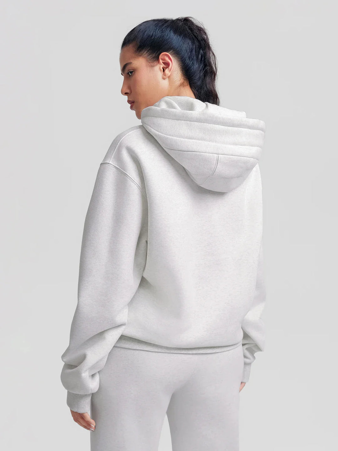 A model wearing a BRXL® Oversized Travel Pullover Hoodie with Headphone Slot