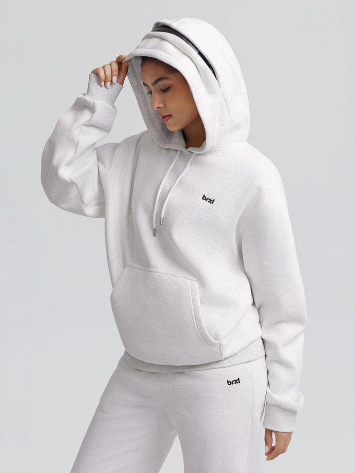 A model wearing a BRXL® Oversized Travel Pullover Hoodie with Headphone Slot
