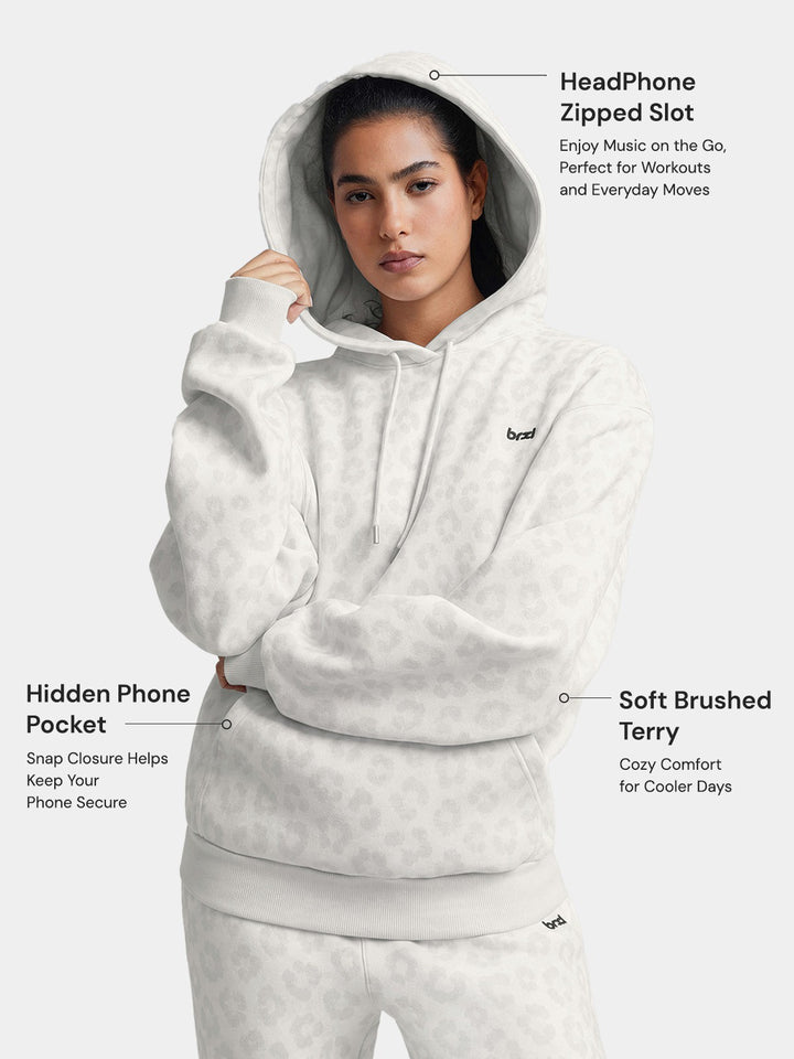 A model wearing a BRXL® Oversized Travel Pullover Hoodie with Headphone Slot