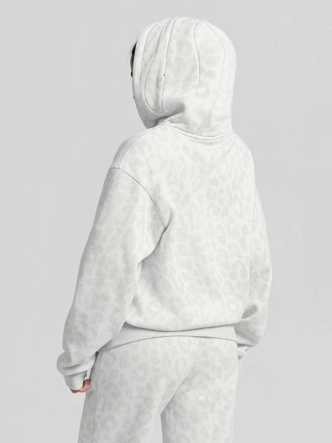 A model wearing a BRXL® Oversized Travel Pullover Hoodie with Headphone Slot