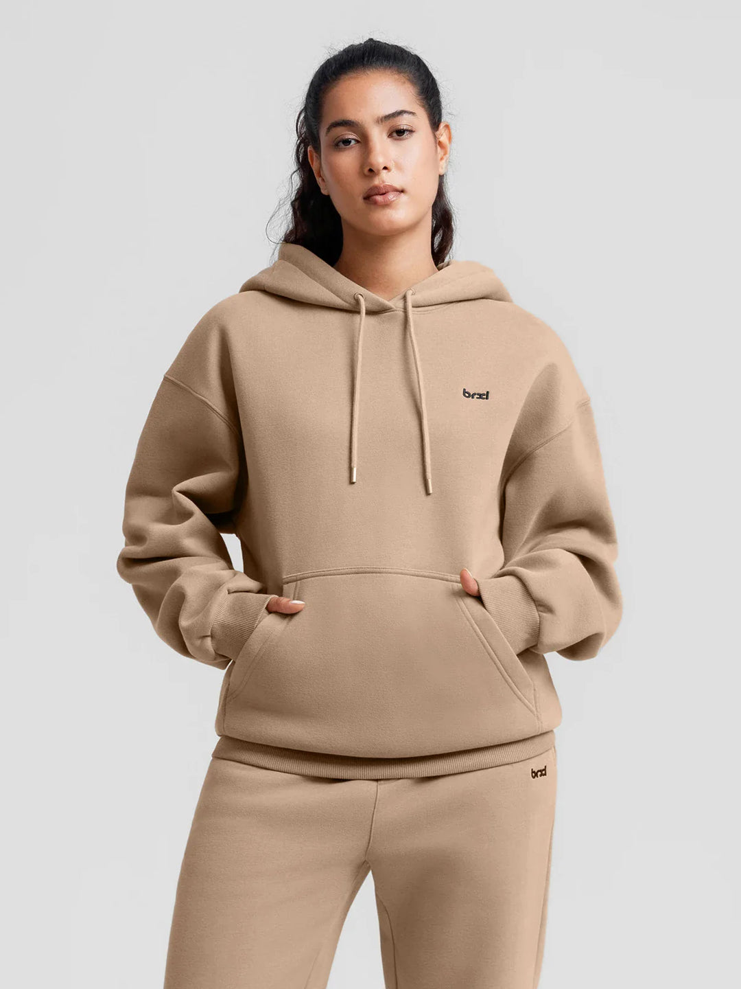 A model wearing a BRXL® Oversized Travel Pullover Hoodie with Headphone Slot Walnut Brown / XS