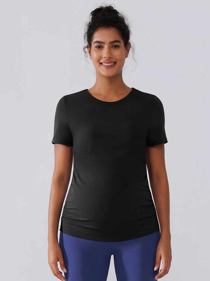 A model wearing a BRXL® Ruched Maternity T Shirts with Shelf Bra in