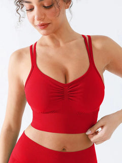 A model wearing a BRXL® Seamless Criss Cross Spaghetti Racerback Sports Bra Red / XS