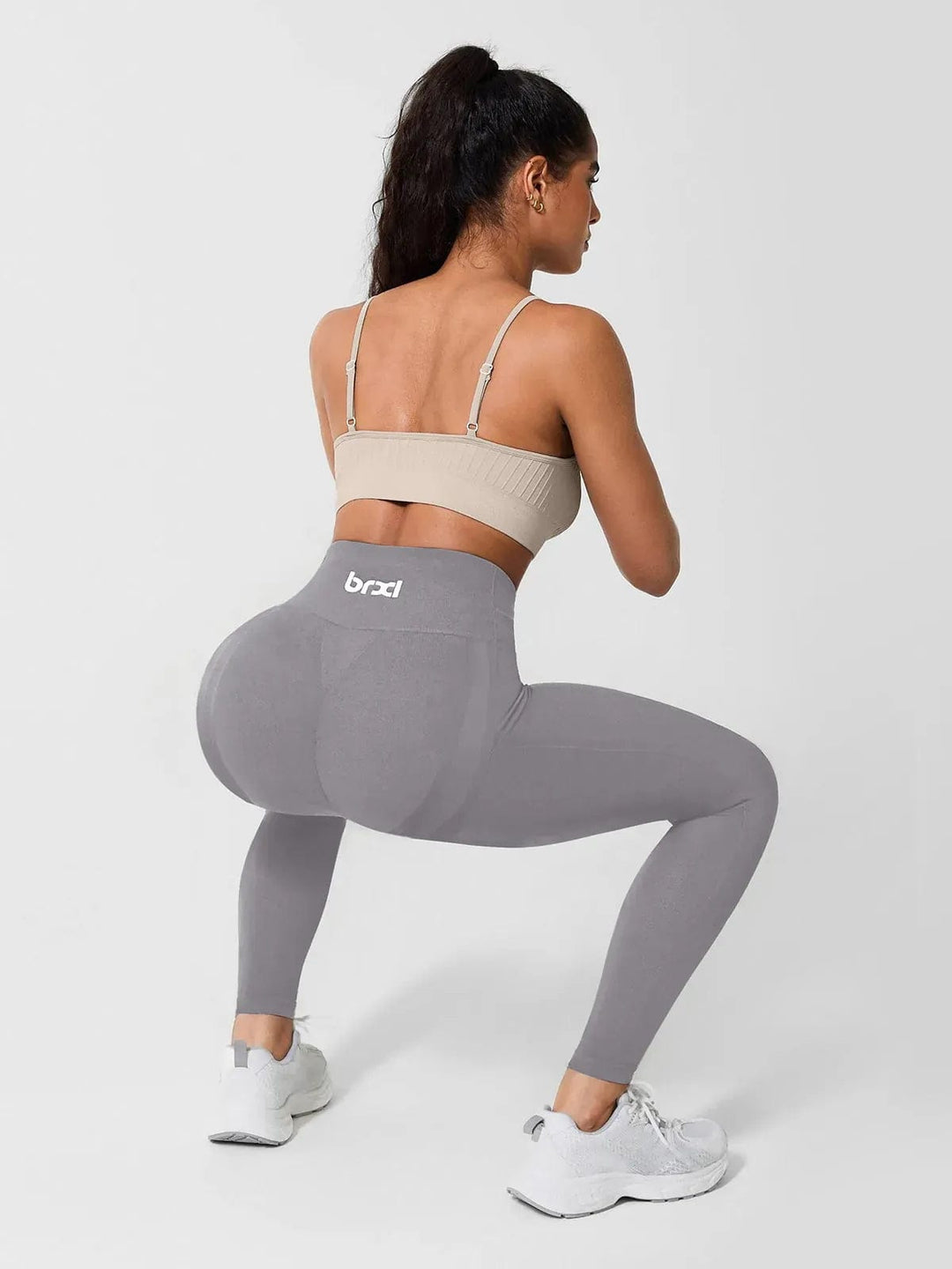 A model wearing a BRXL® Seamless High Waisted Tummy Control Butt-Lifting Leggings,Half Front Zipper Activewear Cropped Top in