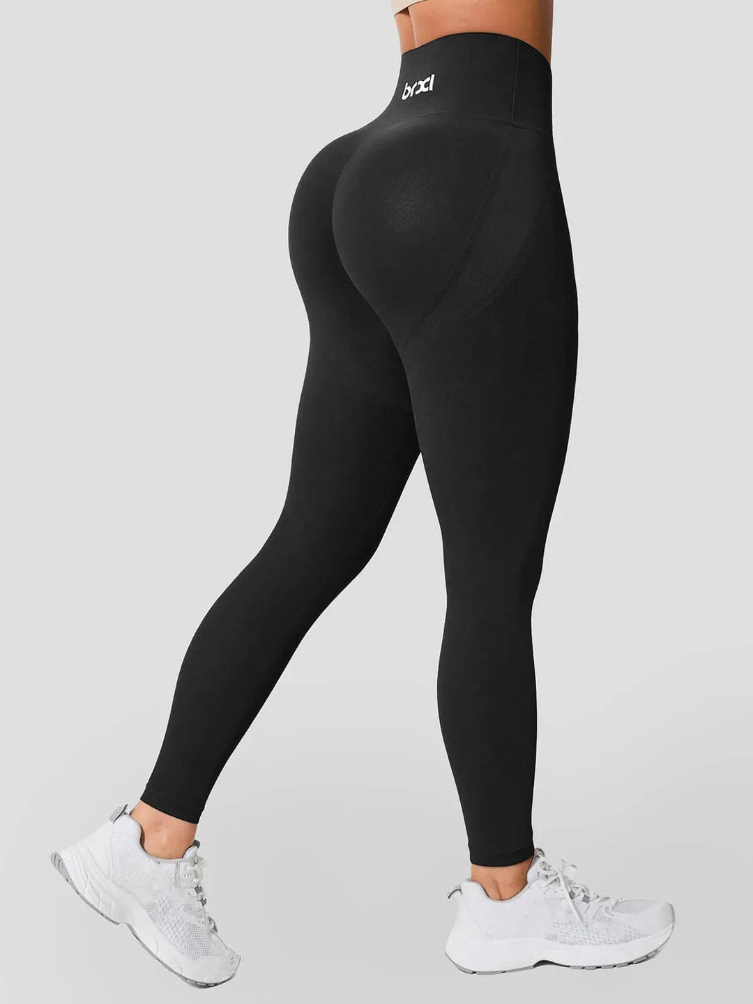 A model wearing a BRXL® Seamless High Waisted Tummy Control Butt-Lifting Leggings,Half Front Zipper Activewear Cropped Top in Legging / Black / XS