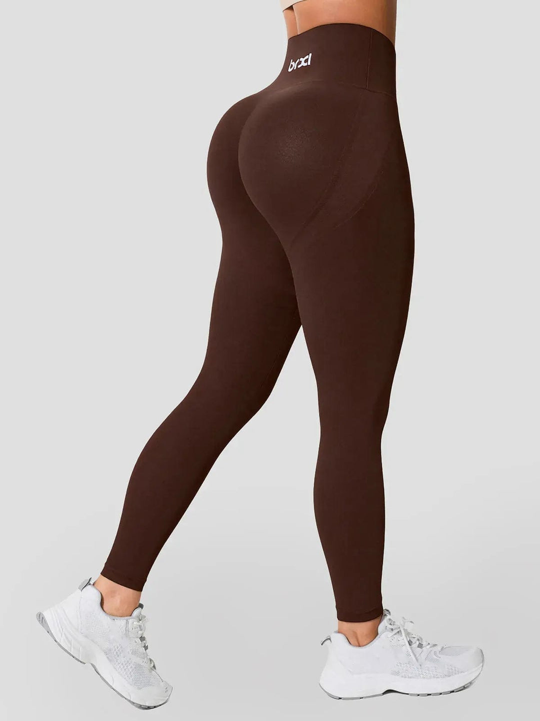 A model wearing a BRXL® Seamless High Waisted Tummy Control Butt-Lifting Leggings,Half Front Zipper Activewear Cropped Top in Legging / Brown / XS