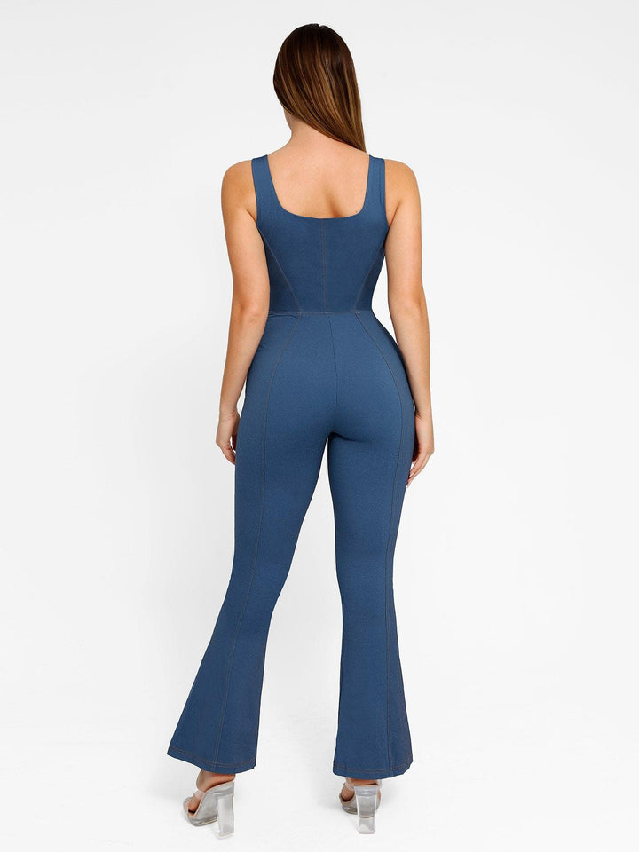 Woman in blue denim square neck sculpting tank jumpsuit with flare legs, viewed from the back.
