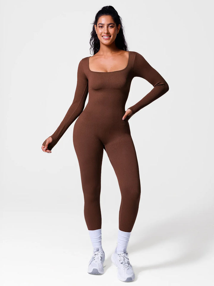 A model wearing a BRXL® Yoga Activewear Jumpsuit Winter Shapewear Long Sleeve Thumb Hole Jumpsuit in Brown / XS