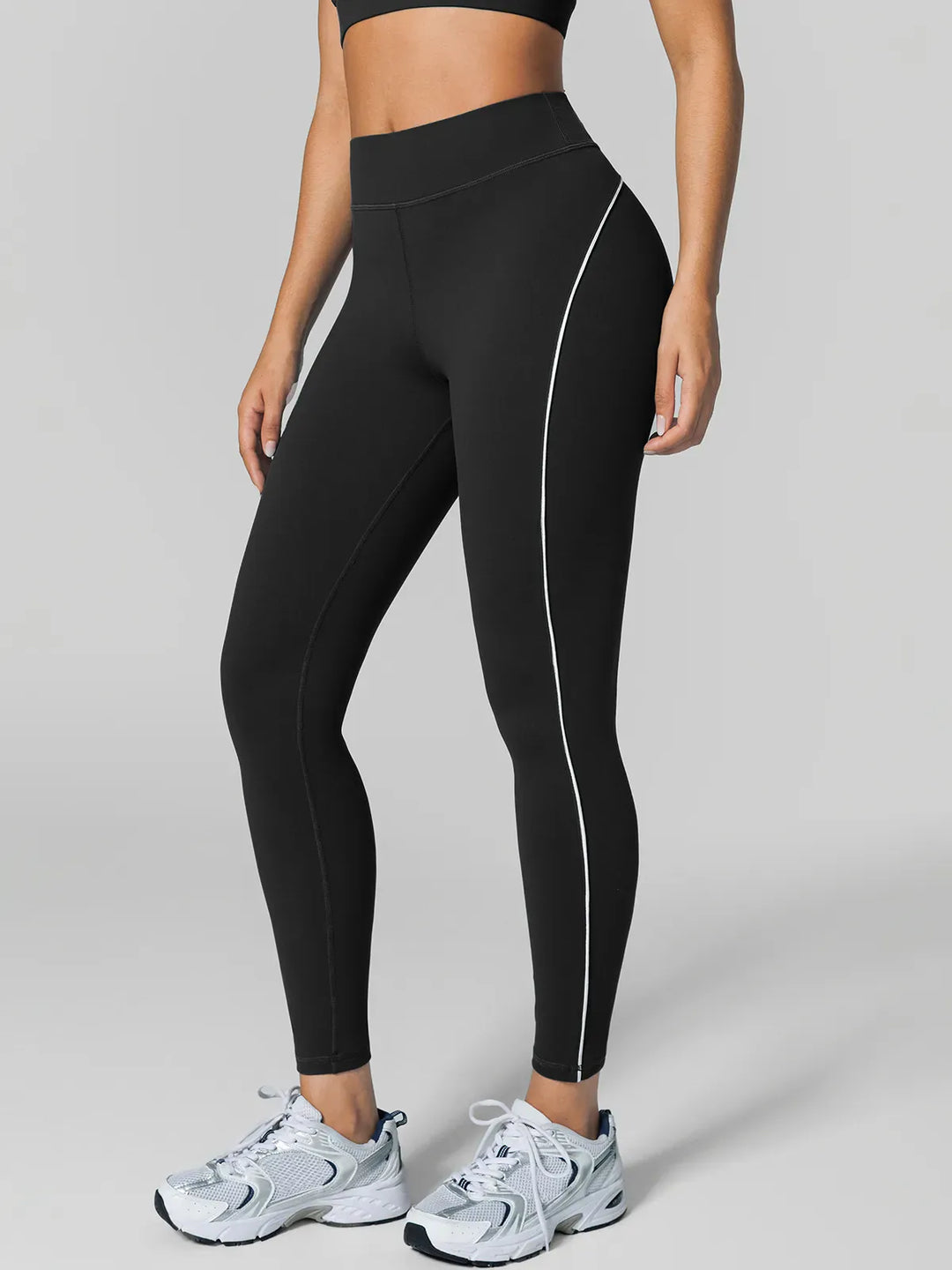A model wearing a BRXL® Tummy Control High Rise Yoga Leggings in Black / XS